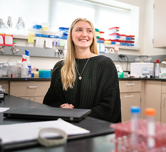 Alumna Melissa Koontz, class of 2012, sits at desk